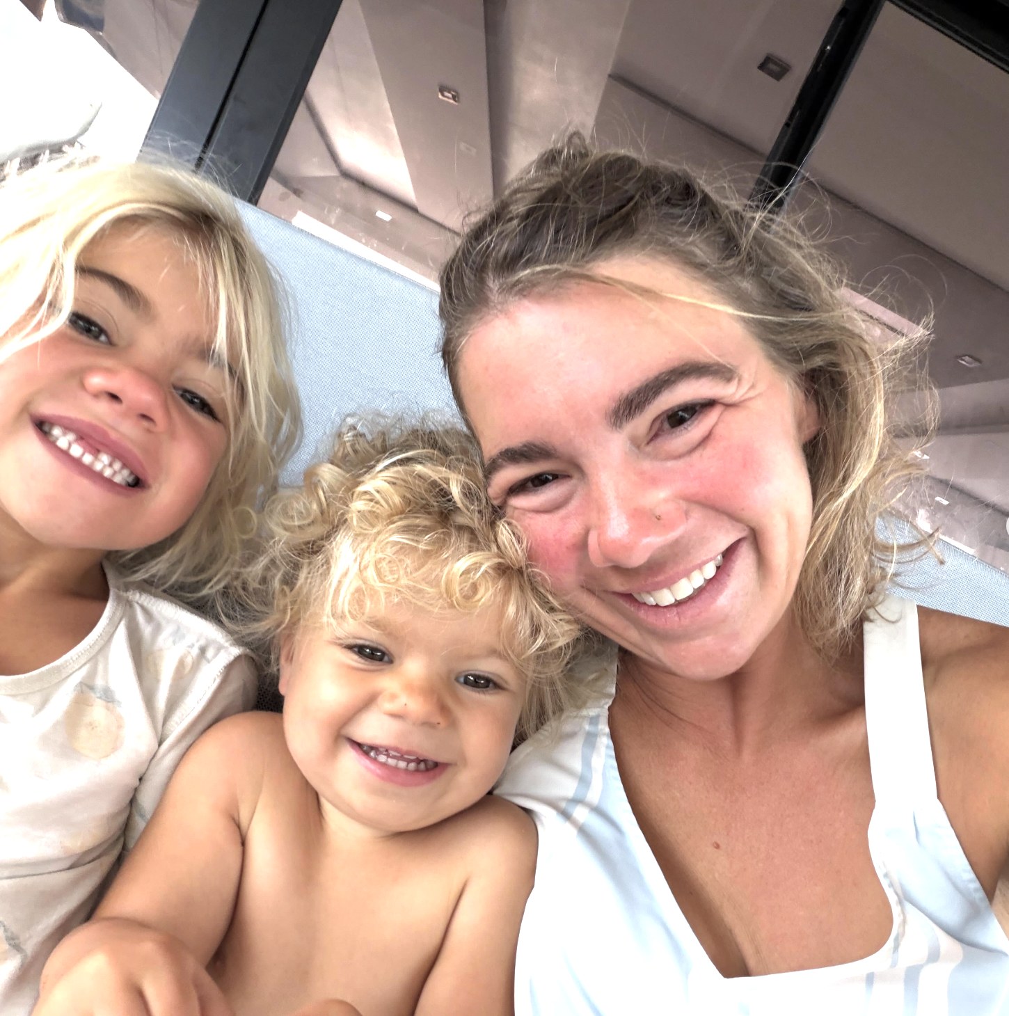 Three family members smiling together aboard the boat.