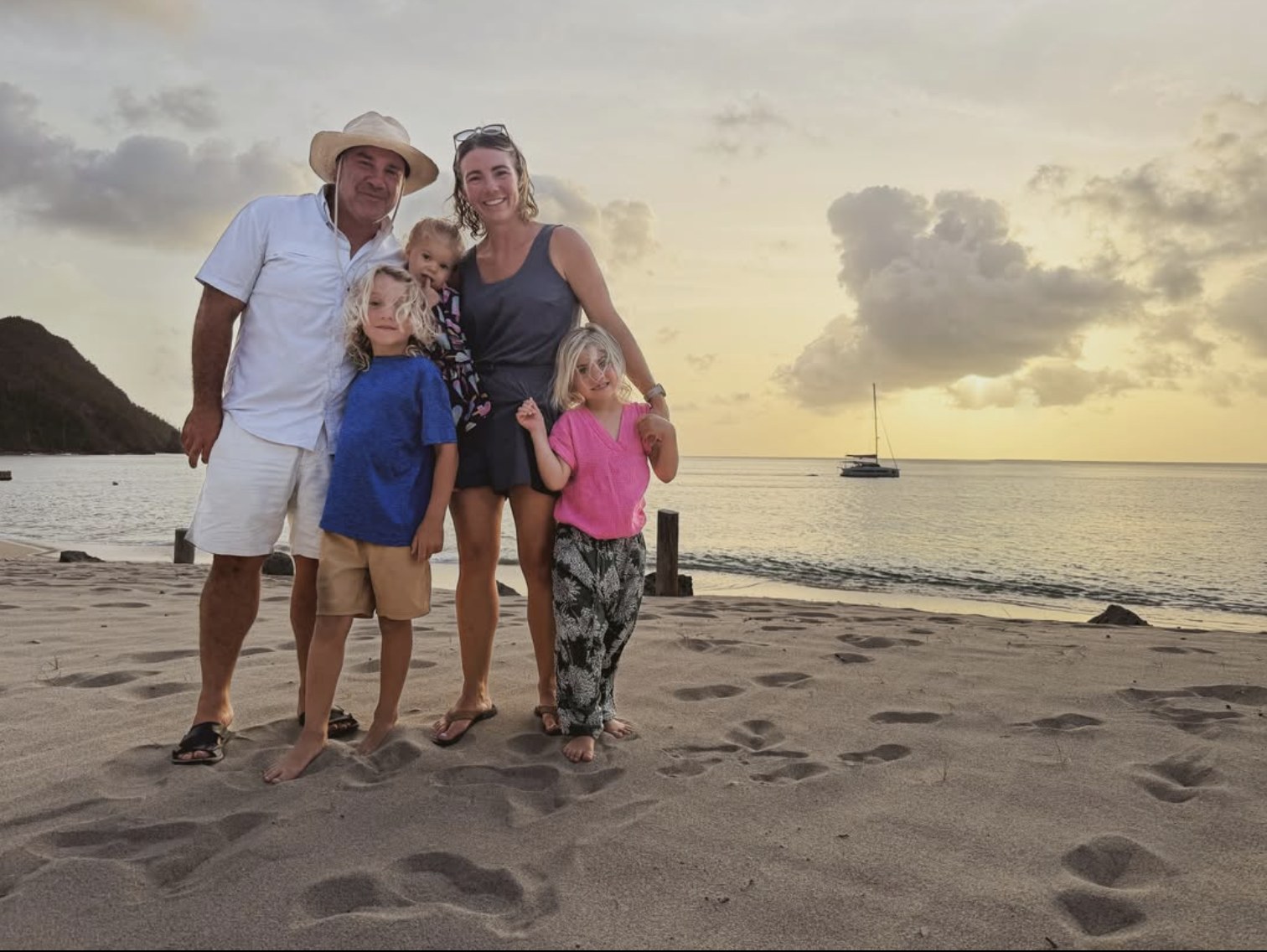 The Boca family of five together on a beach at sunset.