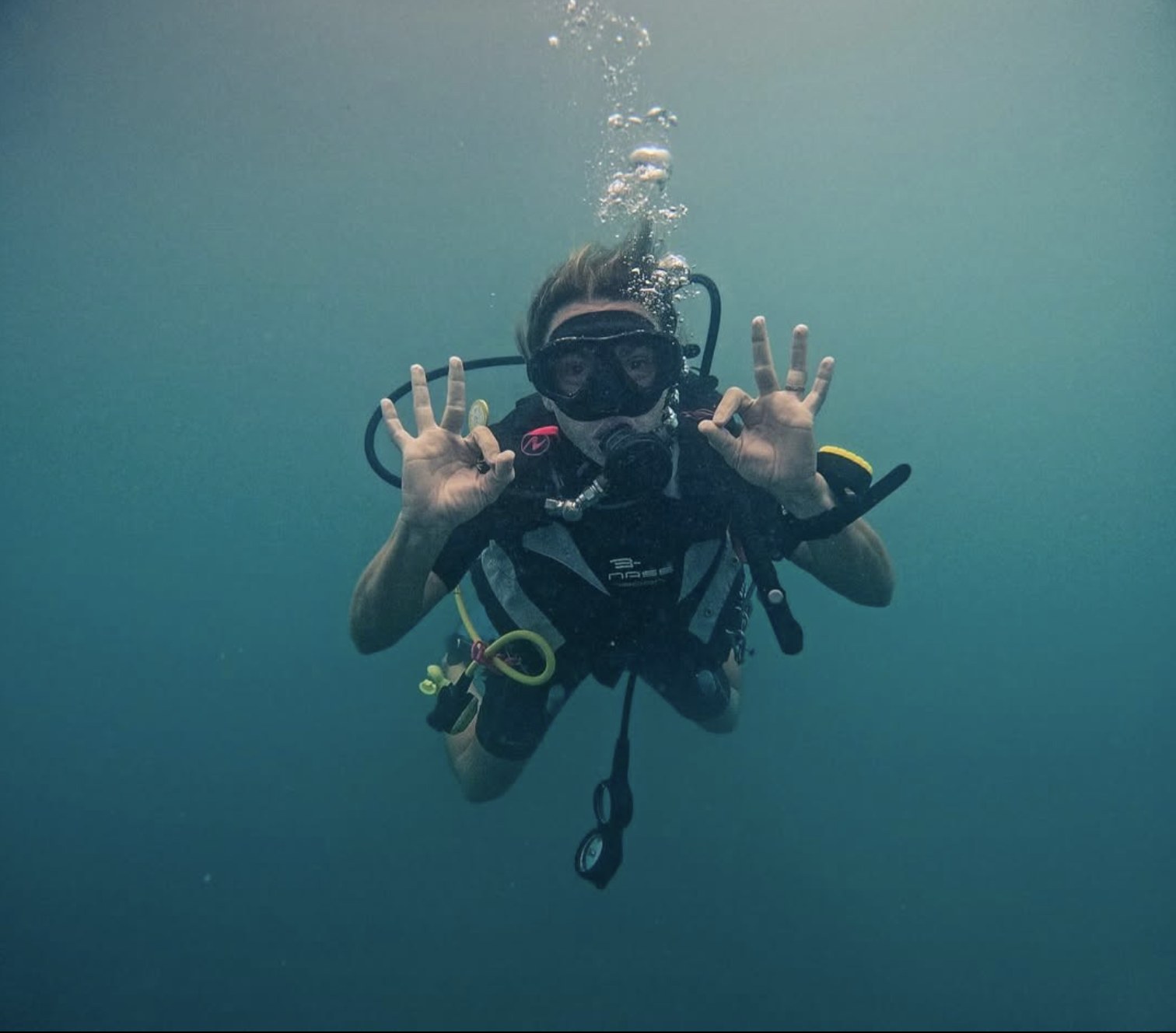 A scuba diver underwater giving an OK sign.